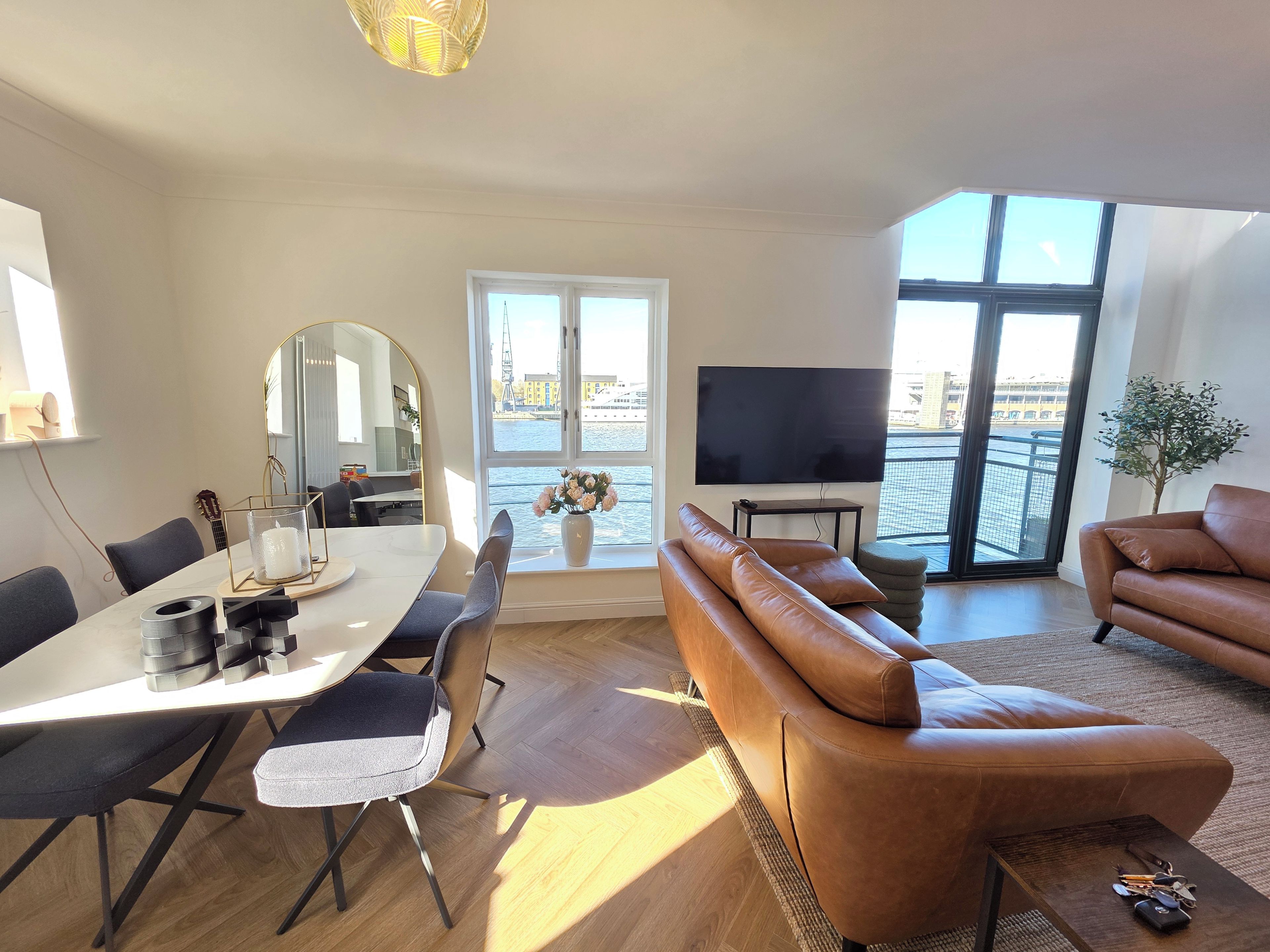 Un salon moderne avec un canapé, une table à manger et un téléviseur.