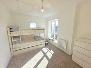A child's bunk bed with a skylight, a radiator, and a window with a view. - Bright Modern 2BR Flat Sleeps 5 Royal Docks (Greater London)