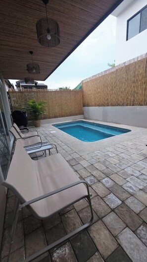 A covered outdoor area with a swimming pool, lounge chairs, and a bamboo fence. - Private Pool Home for 8 | 5 Min to Jacó | 87 (Jaco)