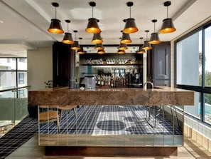 A modern kitchen with a marble countertop, pendant lighting, and a checkered floor. - Luxury 2 BR Loft w Pool, Patio & Menlyn Maine (Pretoria)