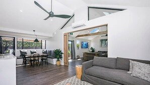 Una sala de estar moderna con sofá, mesa de centro y comedor.