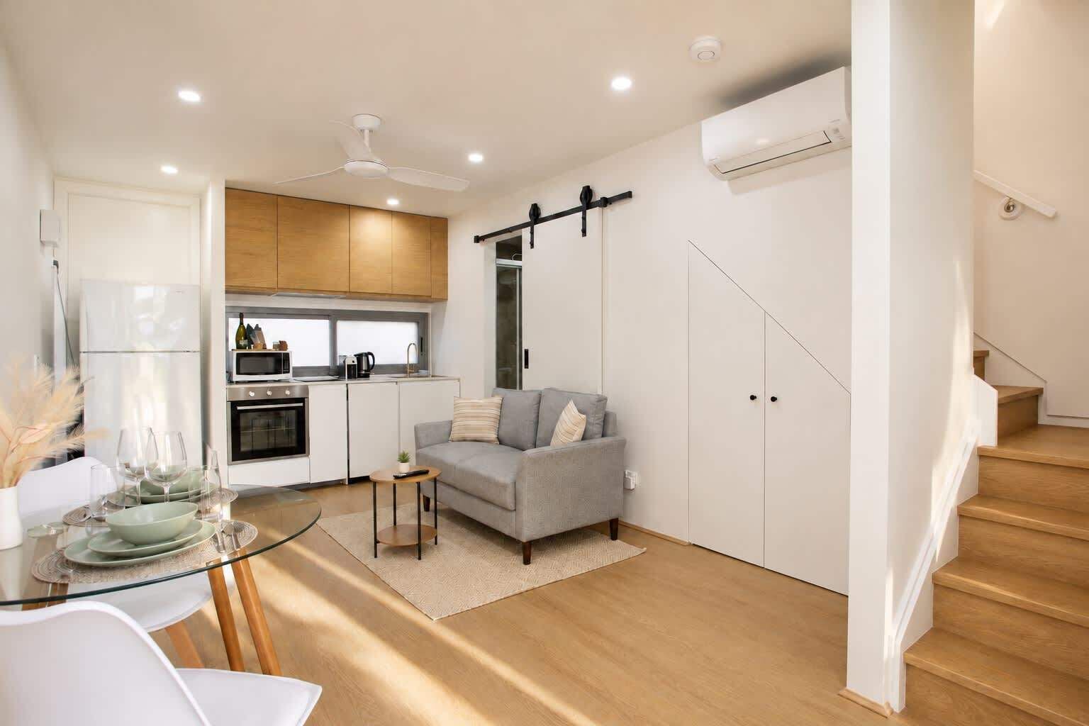 A modern apartment with a kitchen, dining area, and living room.
