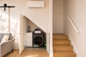 A laundry room with a washing machine, a drying rack, and a small sink. - The Loft | Charming 1BR Glebe, Near Sydney Uni (Glebe)