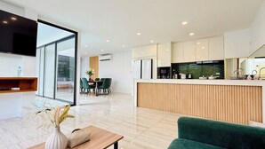 A modern kitchen with a wooden countertop and a built-in oven.