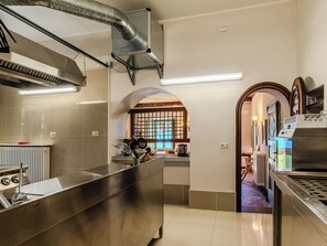 Eine moderne Küche mit Edelstahlgeräten, einer großen Kochinsel und Blick durch ein rundes Fenster.