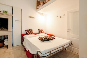 A bedroom with a bed, a wardrobe, a 'WELCOME' sign, and a door. - A wonderful home in the historic district (Castellana Grotte)