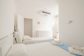 A hotel room with two beds, a white dresser, a ceiling fan, and a window. - A wonderful home in the historic district (Castellana Grotte)