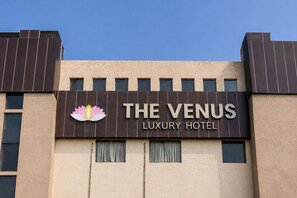 A building with a sign that reads 'THE VENUS LUXURY HOTEL' and a lotus flower logo. - Hotel the venus (Rudrapur)