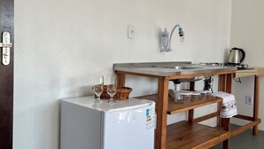 A compact kitchen with a refrigerator, a wooden table with a sink, and a kettle. - SOLAR DO VALE VERDE (Corupá)