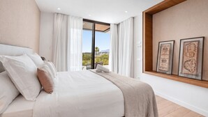 A bedroom with a bed, white curtains, a view of the outdoors, and framed artwork on the wall. - VILLA TROPHY BY VACATION MARBELLA (Marbella)
