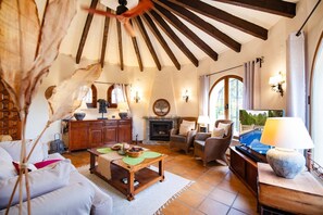 Ein gemütliches Wohnzimmer mit Kamin, bequemen Sitzgelegenheiten und einem Fernseher.