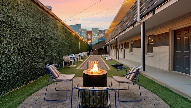 A patio area with a fire pit, outdoor seating, and a view of the cityscape.