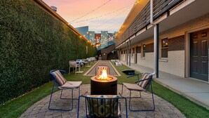 Un patio con una chimenea, asientos exteriores y vistas a la ciudad.