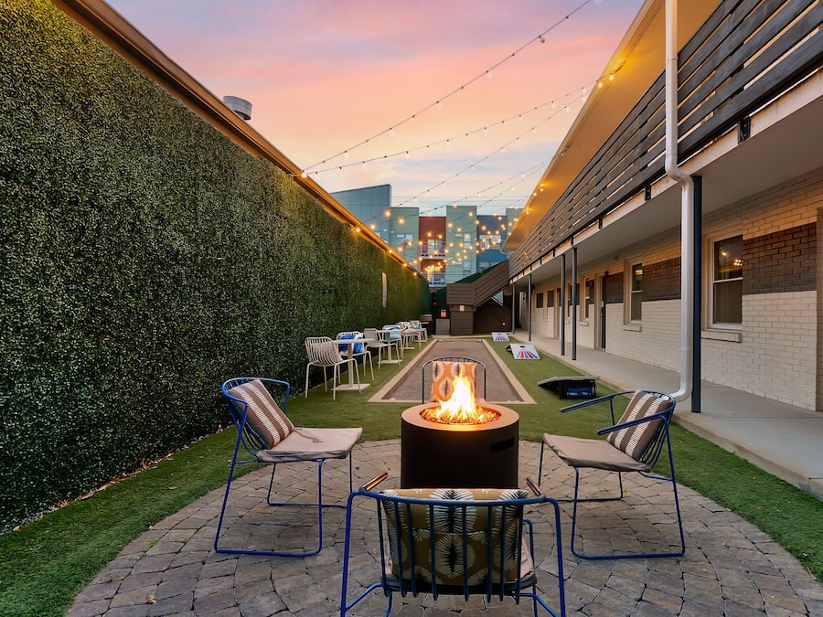 Eine Terrasse mit Feuerstelle, Sitzgelegenheiten und Blick auf die Stadtlandschaft.