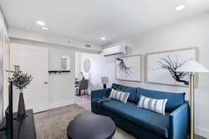 Ein modernes Wohnzimmer mit einer Couch, einem Couchtisch und Kunstwerken an der Wand.