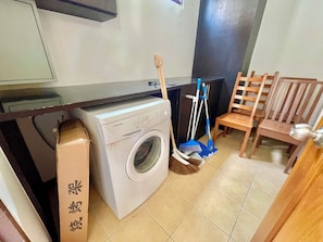 A laundry area with a washing machine, a broom, and a mop. - The Midas Pool Villa (Banglamung)