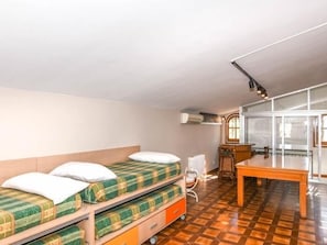 Een kamer met stapelbedden, een bureau en een stoel.