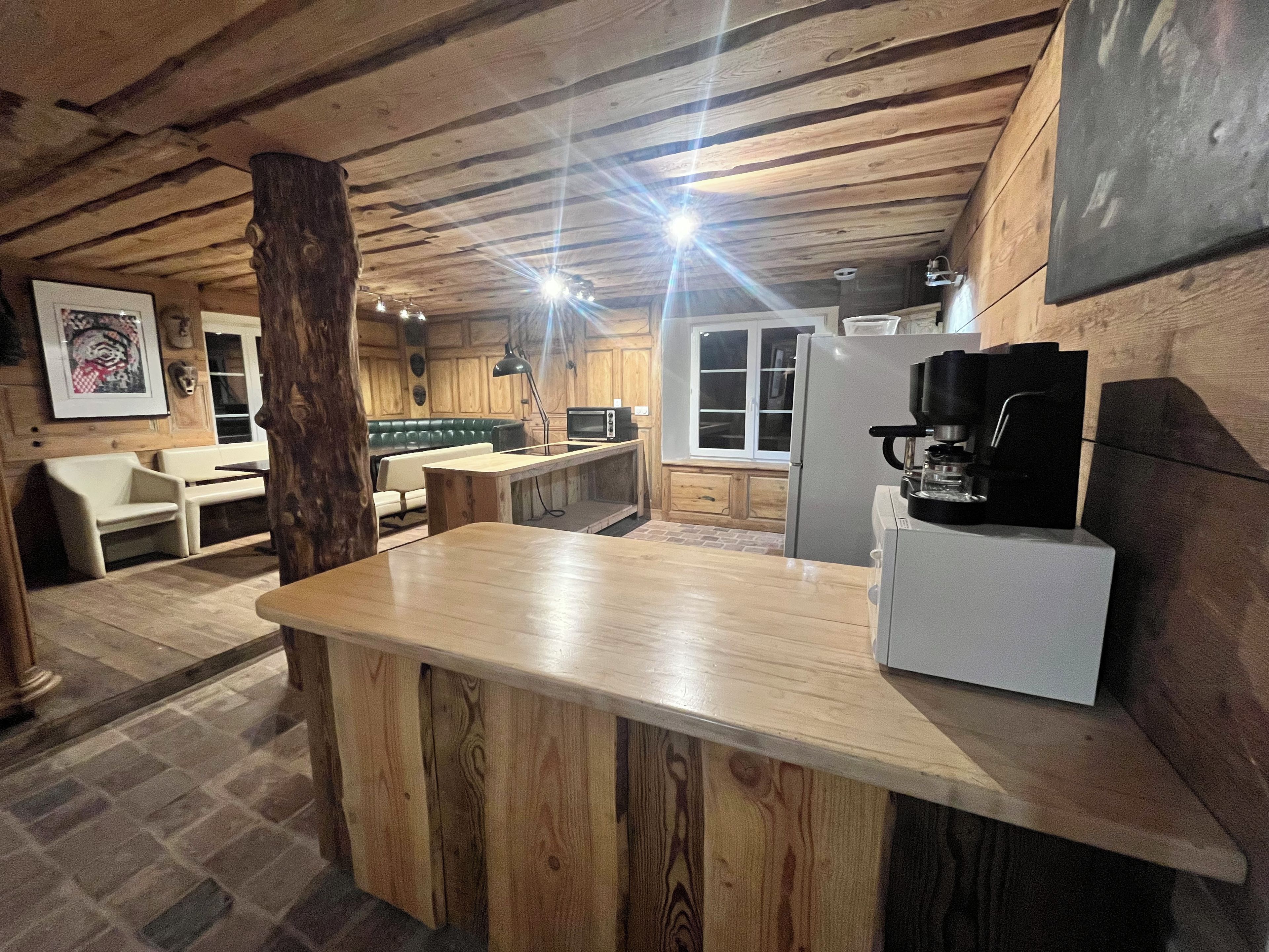 Eine rustikale Küche mit Holzbalken, einer Bar und einer Sitzecke.
