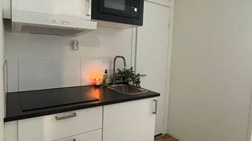 Appartement classique | Cuisine privée | Four à micro-ondes, surface de cuisson, vaisselle et ustensiles