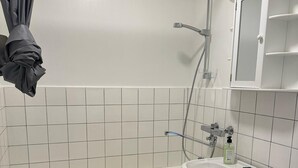 Et badeværelse med badekar, vask og toilet.