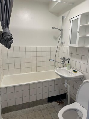 A bathroom with a bathtub, sink, and toilet.
