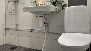 Et moderne badeværelse med bruser, vask og toilet.
