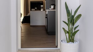 A modern interior with a potted plant, a kitchen area, and a doorway leading to another room. - In the heart of Salento, suites with private hot tubs (Cutrofiano)