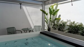 A hot tub with a view of greenery and a table with chairs. - In the heart of Salento, suites with private hot tubs (Cutrofiano)