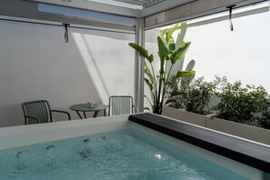 A hot tub with a view of greenery and a table with chairs. - In the heart of Salento, suites with private hot tubs (Cutrofiano)