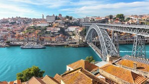 Un paisaje urbano con un puente destacado, edificios históricos y un río.
