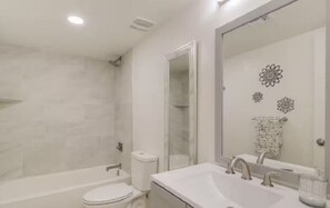 A modern bathroom with a bathtub, toilet, and sink. - 2-bedroom townhome in beautiful Tucson! (Tucson)