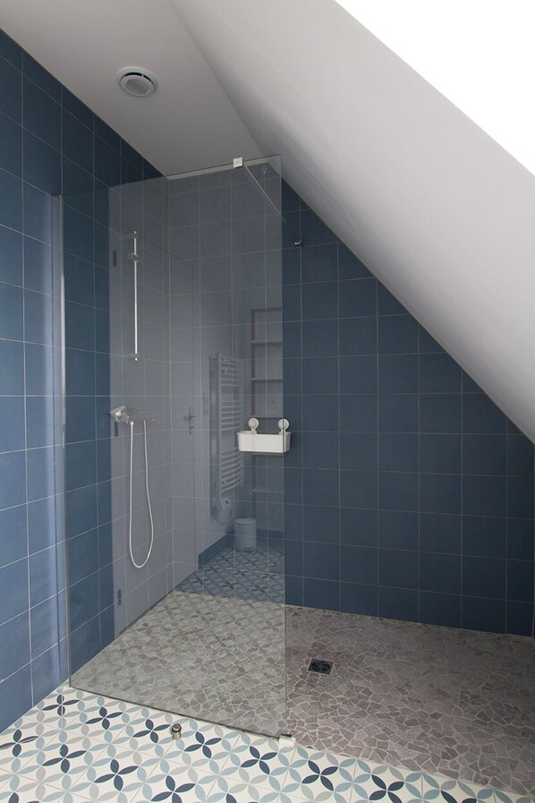 A shower area with a glass door, tiled walls, and a patterned floor. - New House - Ocean View - Aberwrac'h Harbor (Landéda)