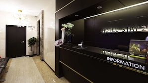A hotel reception desk with a sign reading 'HOTEL STAY 24 INFORMATION.' - Stay25 (Seongnam)