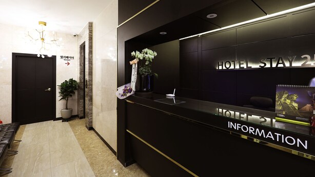 A hotel reception desk with a sign reading 'HOTEL STAY 24 INFORMATION.' - Stay25 (Seongnam)