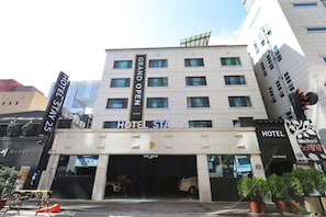 Un hotel con un letrero que dice 'HOTEL STAY 25' y 'GRAN APERTURA'.