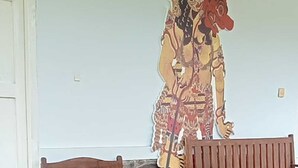 A room with a tiled floor, two wooden benches, and a wall with a large decorative painting. - Hepi Bungalow Lovina Bali (Buleleng)