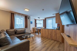 Uma sala de estar moderna com um sofá, mesa de centro e um espaço de jantar com mesa e cadeiras de madeira.