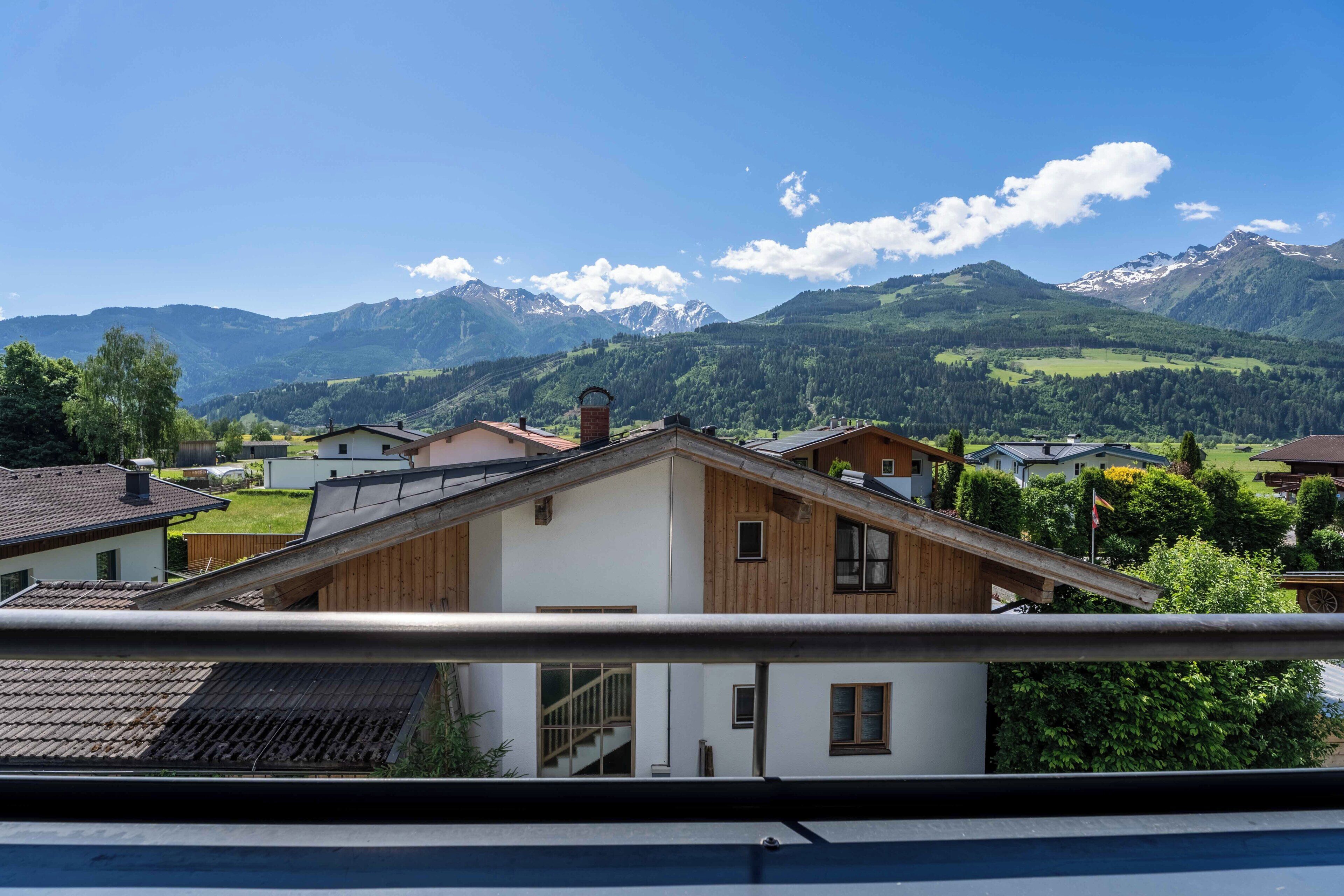 Un quartier résidentiel avec des maisons, un bâtiment en bois et une chaîne de montagnes en arrière-plan.