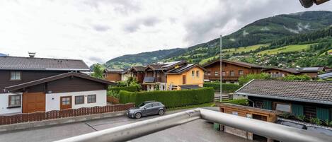 Un quartiere residenziale con case, un'auto e una montagna sullo sfondo.