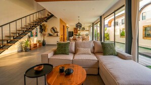 Ein modernes Wohnzimmer mit Sofa, Couchtisch und einer Treppe.
