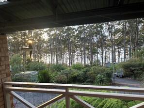 Un espacio al aire libre techado con vista a un bosque.