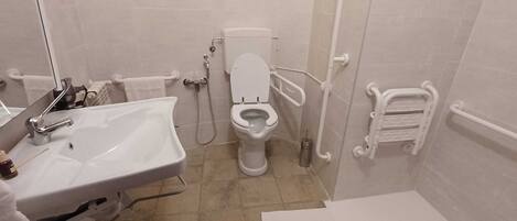 A bathroom with a white sink, toilet, and shower.