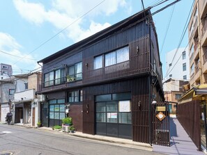 A two-story building with large windows, a balcony, and a gated entrance. - Nagomi Stay Tokyo Sumida Hikifune (Sumida City)