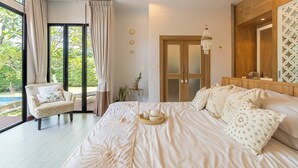 A bedroom with a large bed, a chair, a wooden ceiling, a door, and a view of greenery. - Premium 3BR Pool Villa In Cherngthalay (Choeng Thale)