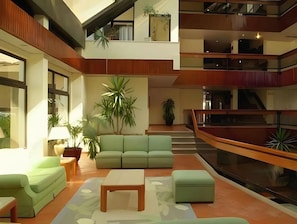 A spacious interior with a green sofa set, a coffee table, and potted plants. - Huma by Umbral (Albufeira)