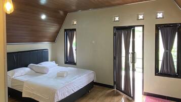 Un dormitorio con cama, techo de madera y piso pulido.