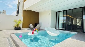A swimming pool with inflatable toys, a seating area with chairs, and a potted plant. - NORD House J21 (Banglamung)