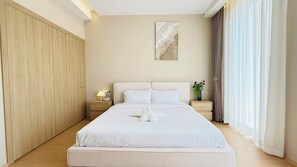 A hotel room with a large bed, wooden wardrobe, bedside tables, and a painting on the wall. - NORD House J21 (Banglamung)