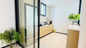 A modern kitchen with a refrigerator, microwave, and sink. - NORD House J21 (Banglamung)