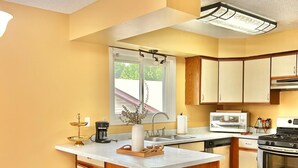 Una cucina moderna con isola centrale, elettrodomestici integrati e un'ampia finestra.